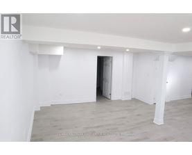 A spacious room with a doorway leading to another room.