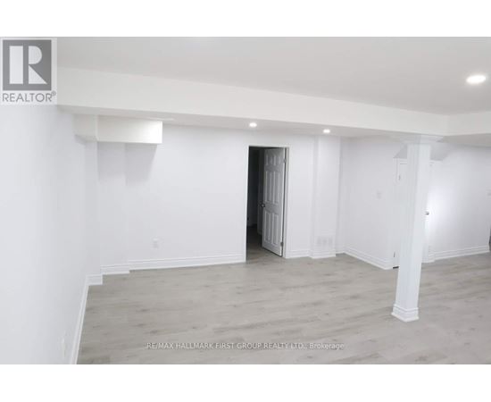 A spacious room with a doorway leading to another room.