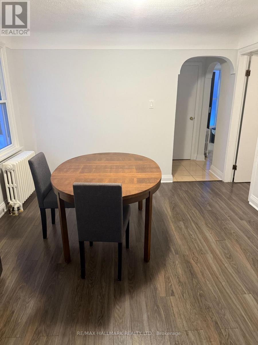 A dining room with a round wooden table and chairs.