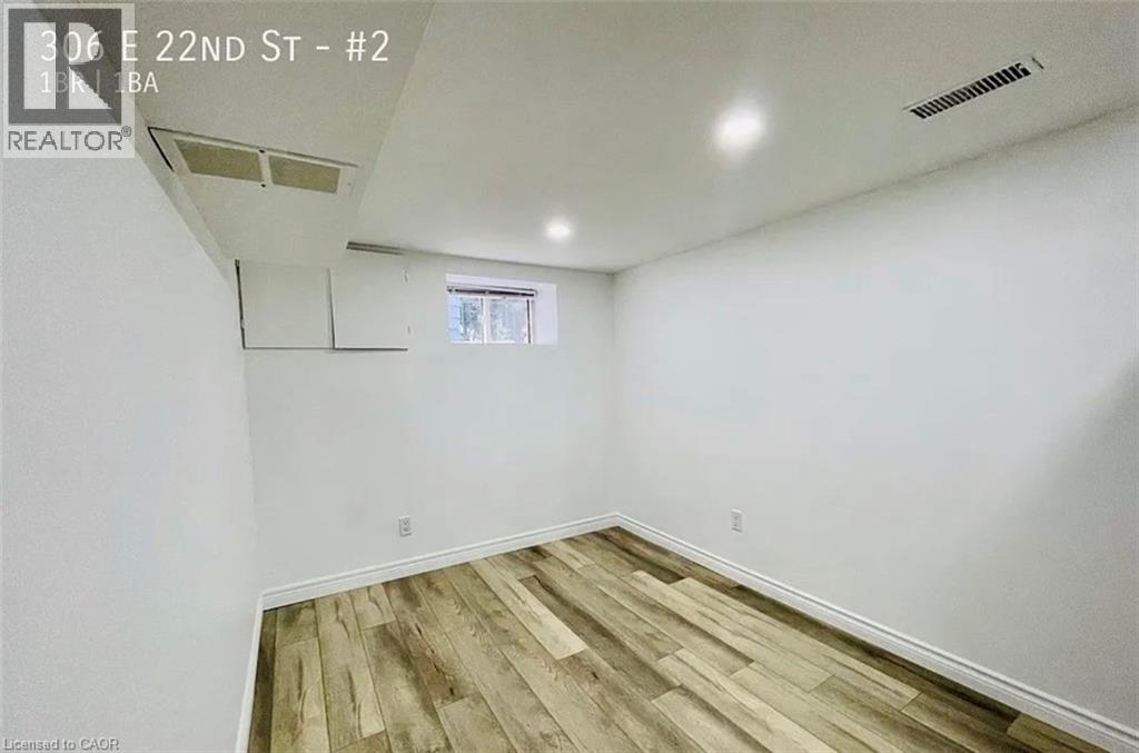 A room with wooden flooring and white walls.
