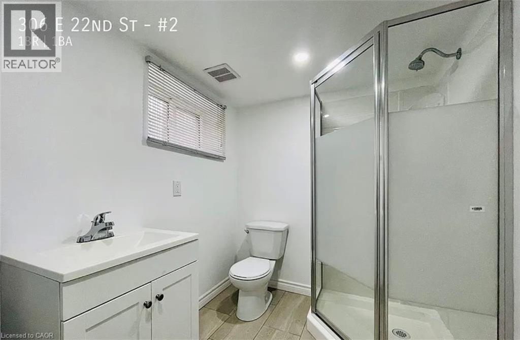 A bathroom with a toilet, sink, and shower.