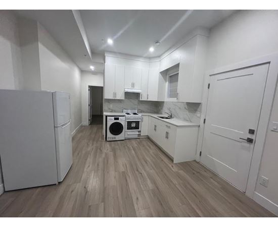 A kitchen with white cabinets and a washer and dryer in it.