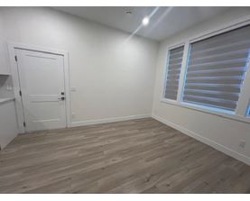 A room with a white door and a window with blinds.