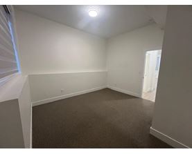 A room with a carpeted floor and a ceiling light.