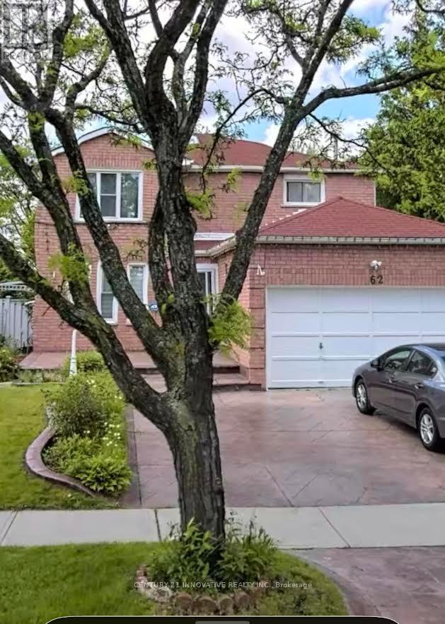 A tree in front of a house with a garage door number 62.