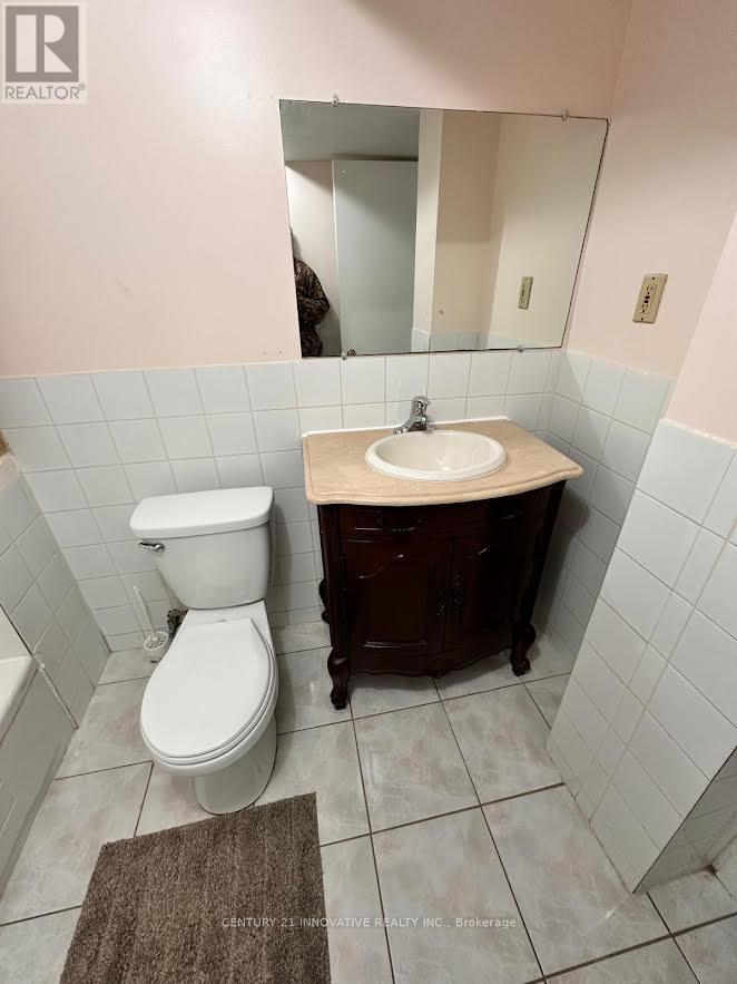 A white toilet sits next to a sink in a bathroom.