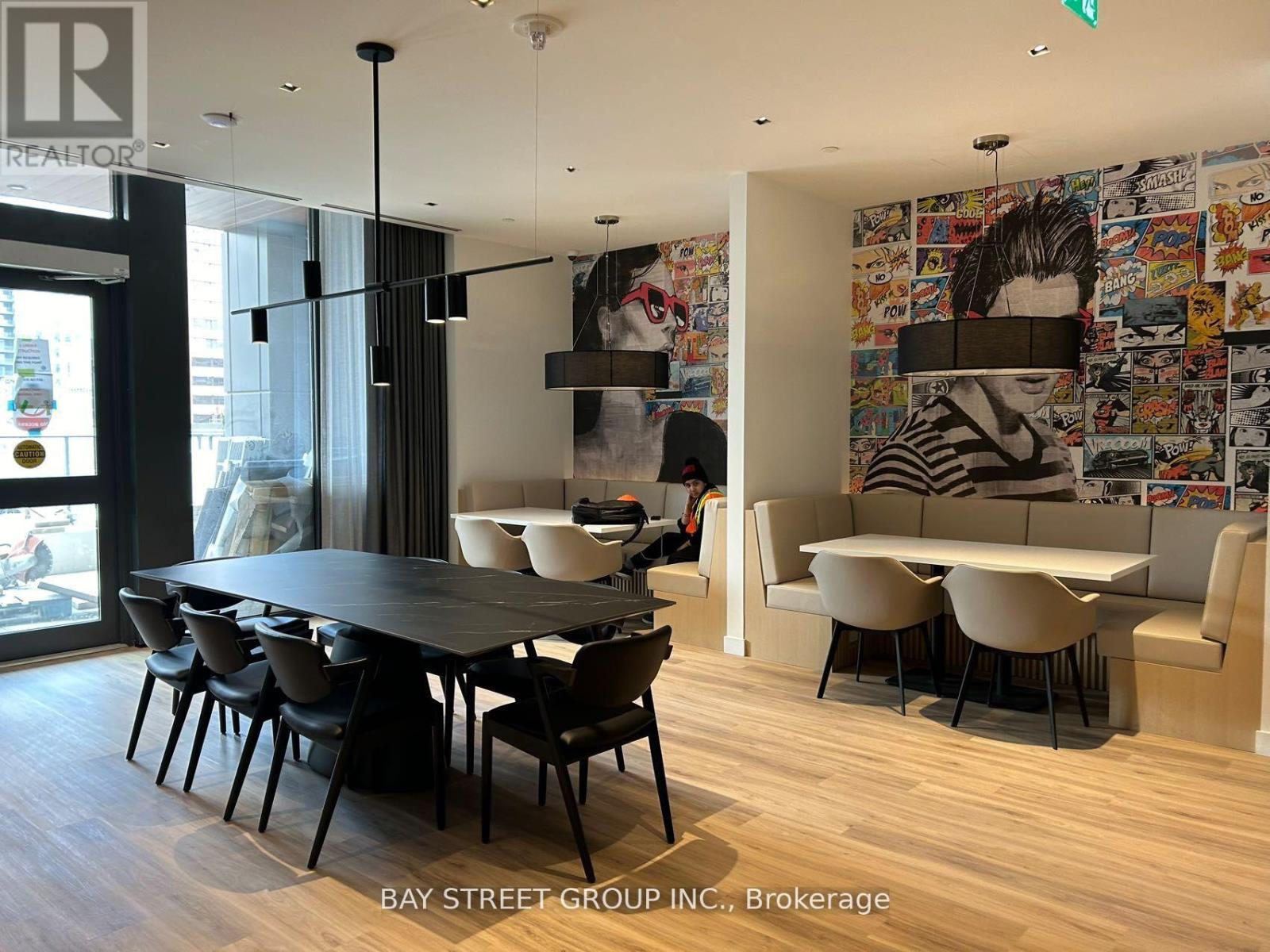 A dining room with a table and chairs and a wall of posters.