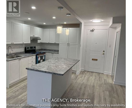 A kitchen with white cabinets and a marble island.