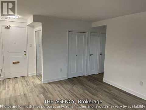 A white door with a brass handle is in a room with white walls and wood flooring.
