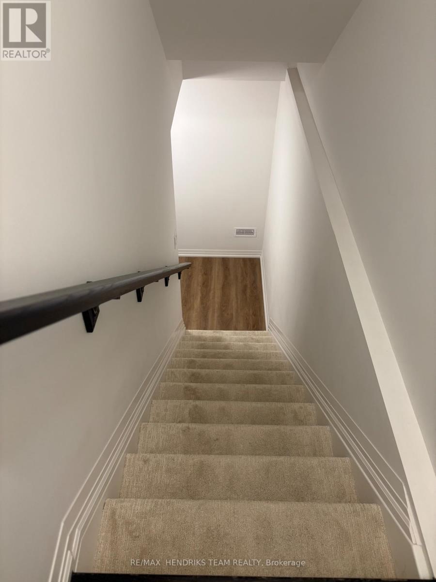 A staircase with beige carpeted steps and white walls.