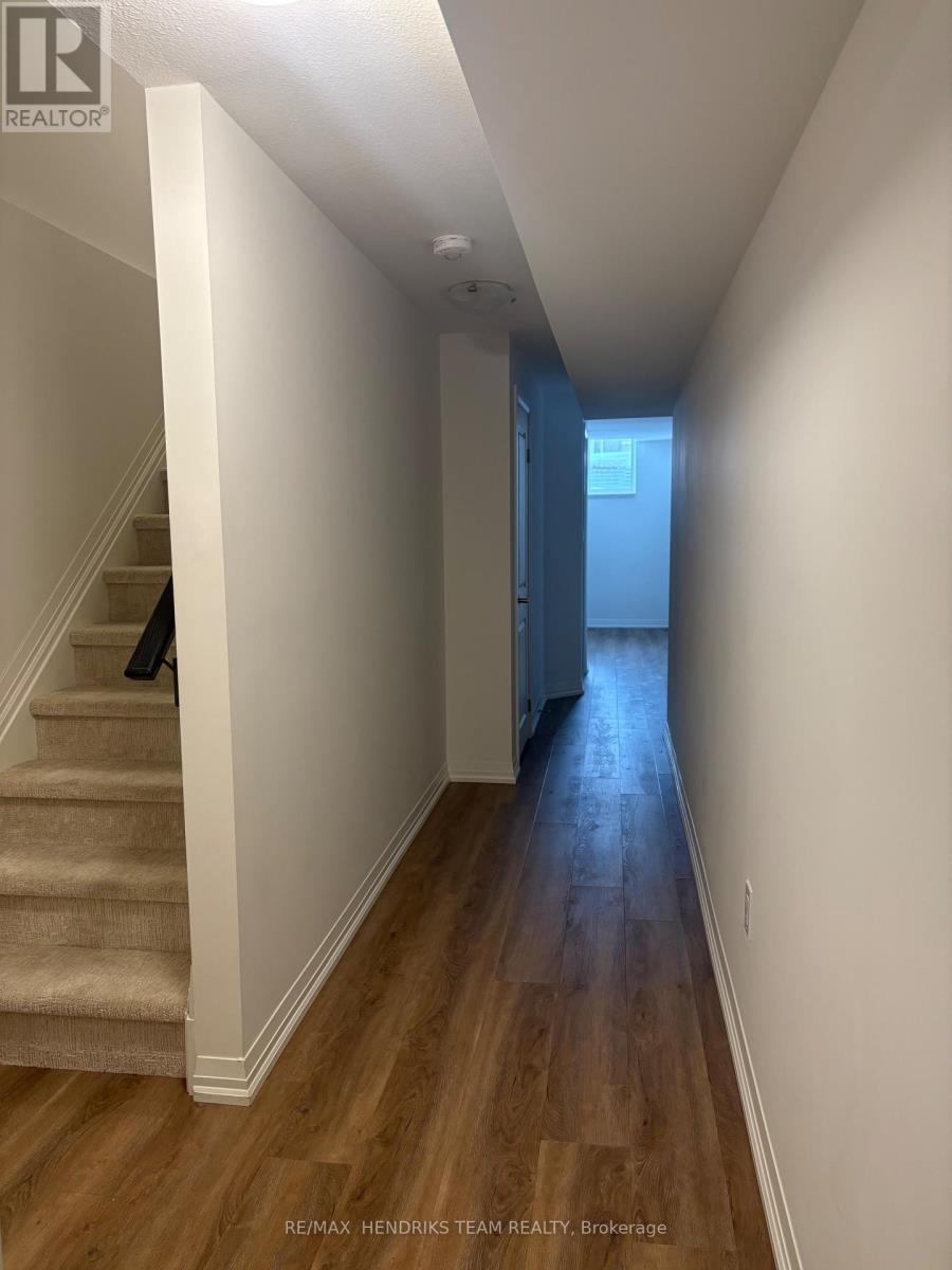 A hallway with wooden floors and white walls.