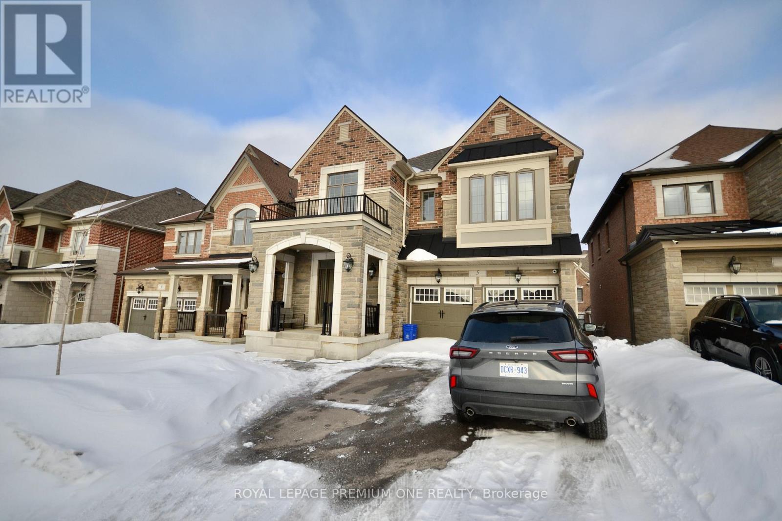 A car is parked in front of a house with snow on the ground.