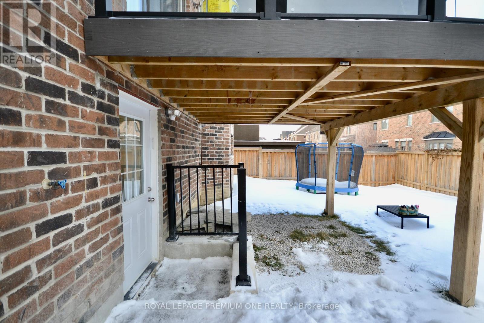 A patio with a white door and a black gate.
