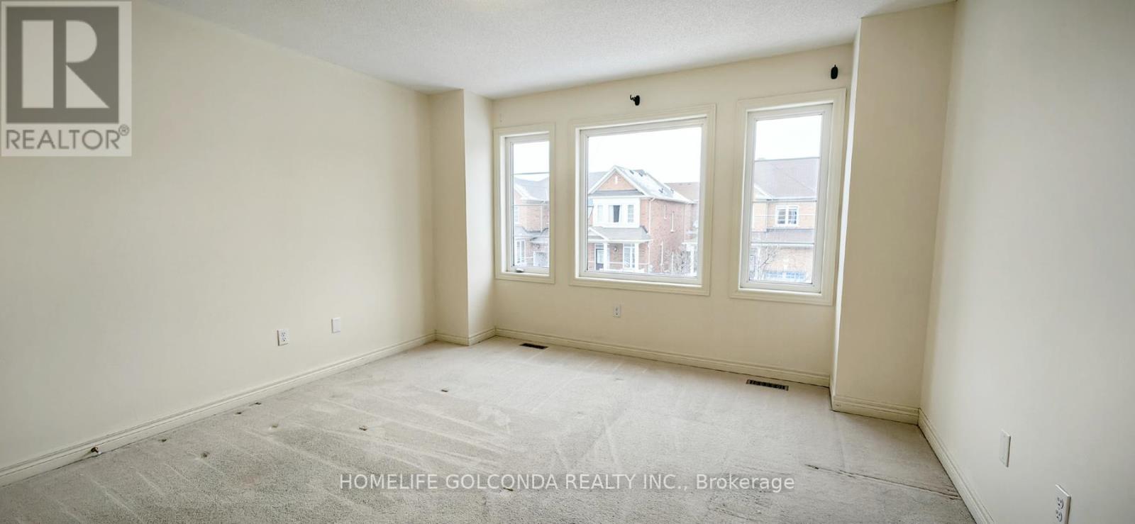 A room with a large window and a view of a building across the street.