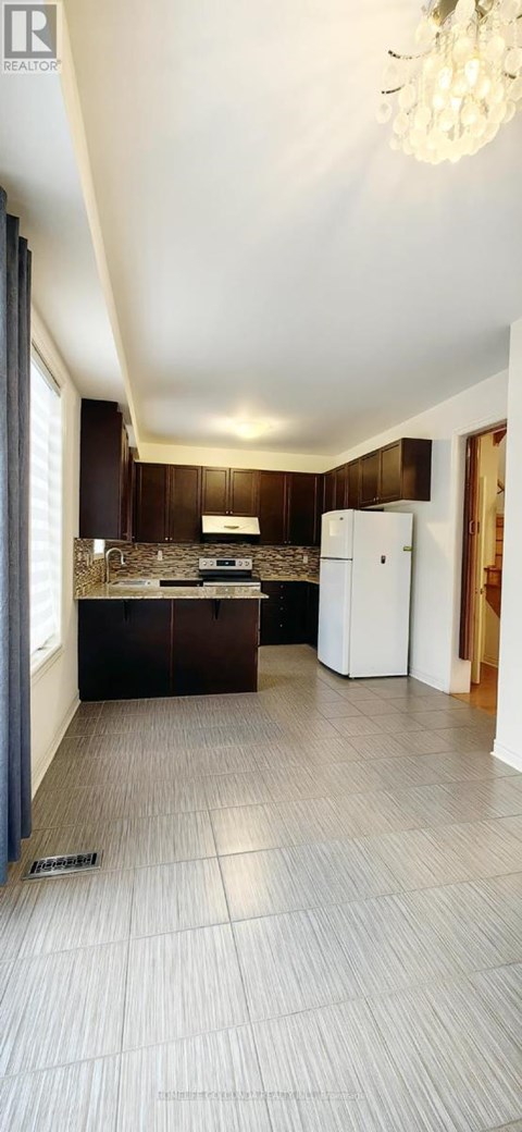 A kitchen with dark wood cabinets and a white refrigerator.
