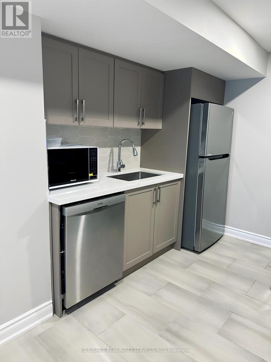 A kitchen with a stainless steel dishwasher and refrigerator.