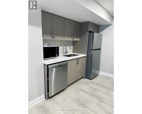 A kitchen with a stainless steel dishwasher and refrigerator.