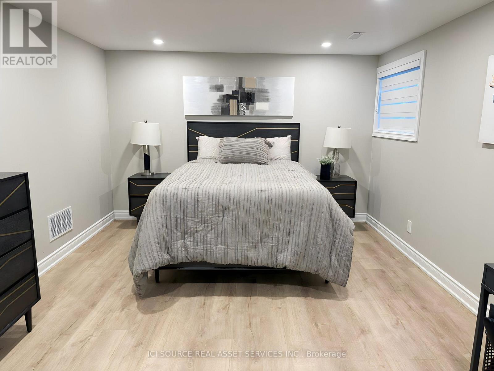 A bedroom with a large bed and two nightstands.