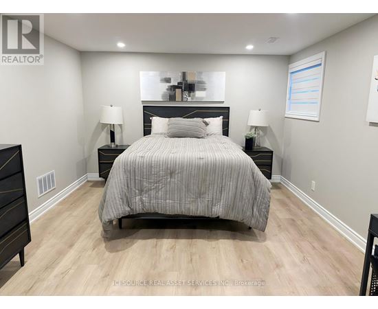 A bedroom with a large bed and two nightstands.