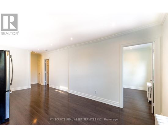 A spacious room with wooden floors and white walls.