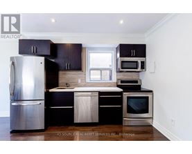 A kitchen with black cabinets and stainless steel appliances.