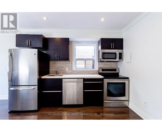 A kitchen with black cabinets and stainless steel appliances.