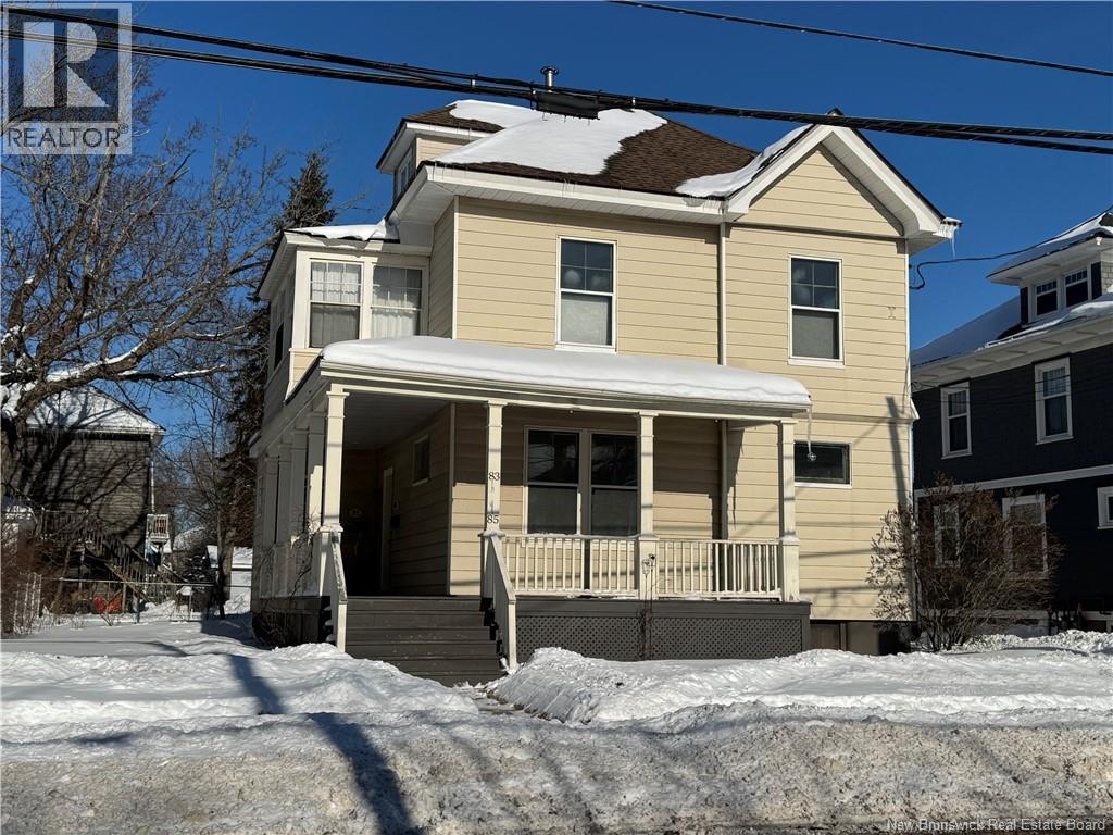 A house with a snow-covered roof and a porch.
