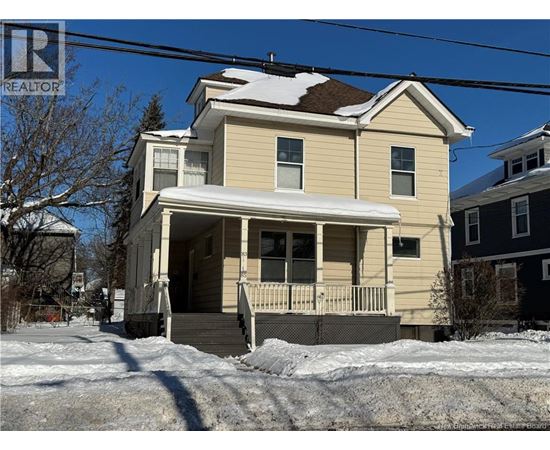 A house with a snow-covered roof and a porch.