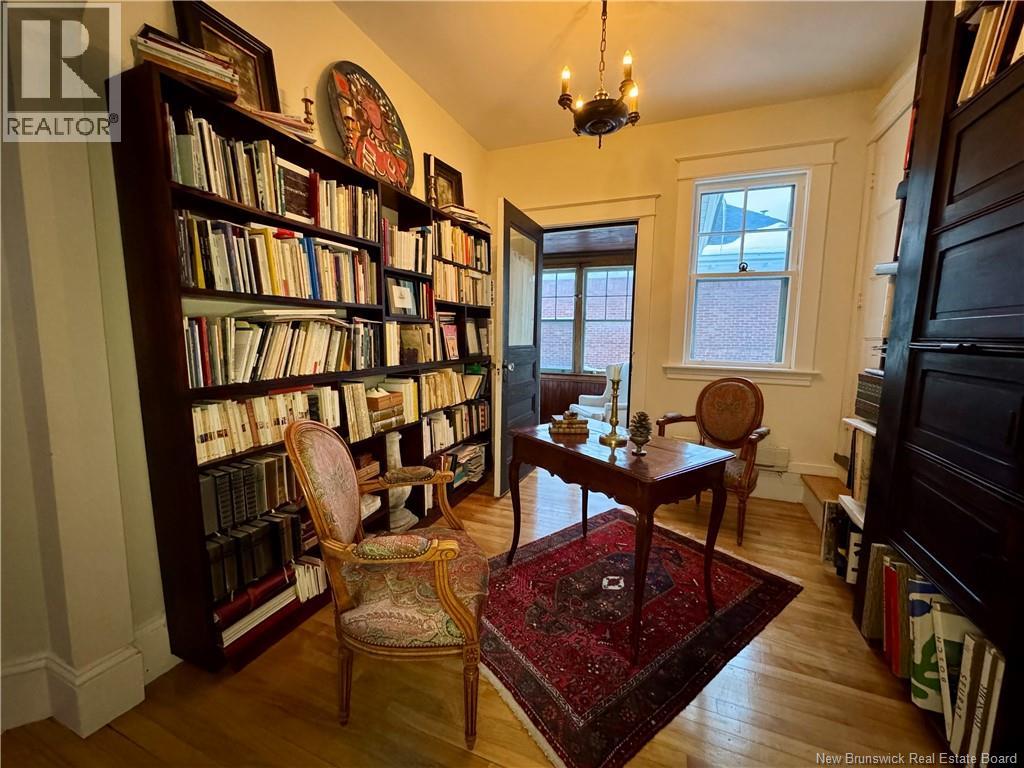 A room with a bookshelf filled with books and a chair in front of it.