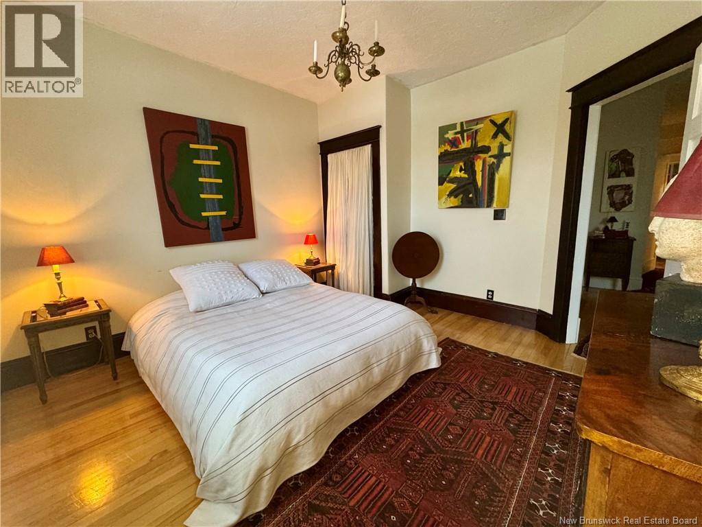 A bedroom with a large bed and a chandelier.