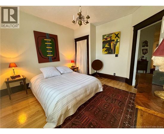 A bedroom with a large bed and a chandelier.