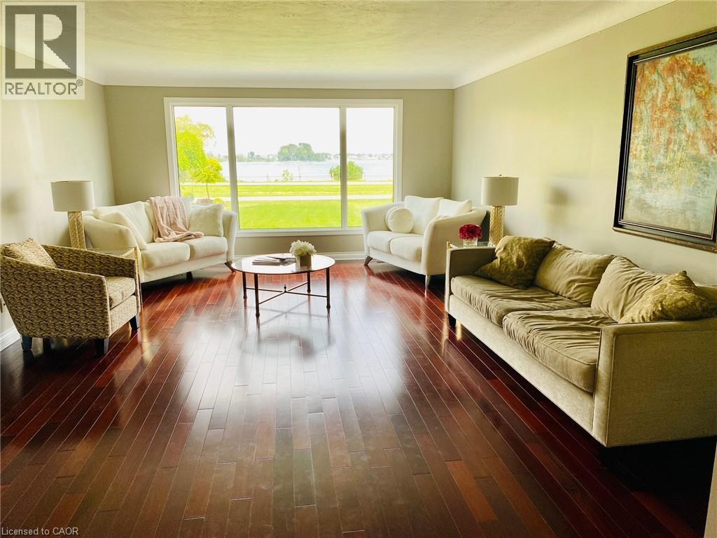 A living room with a large window and a painting on the wall.