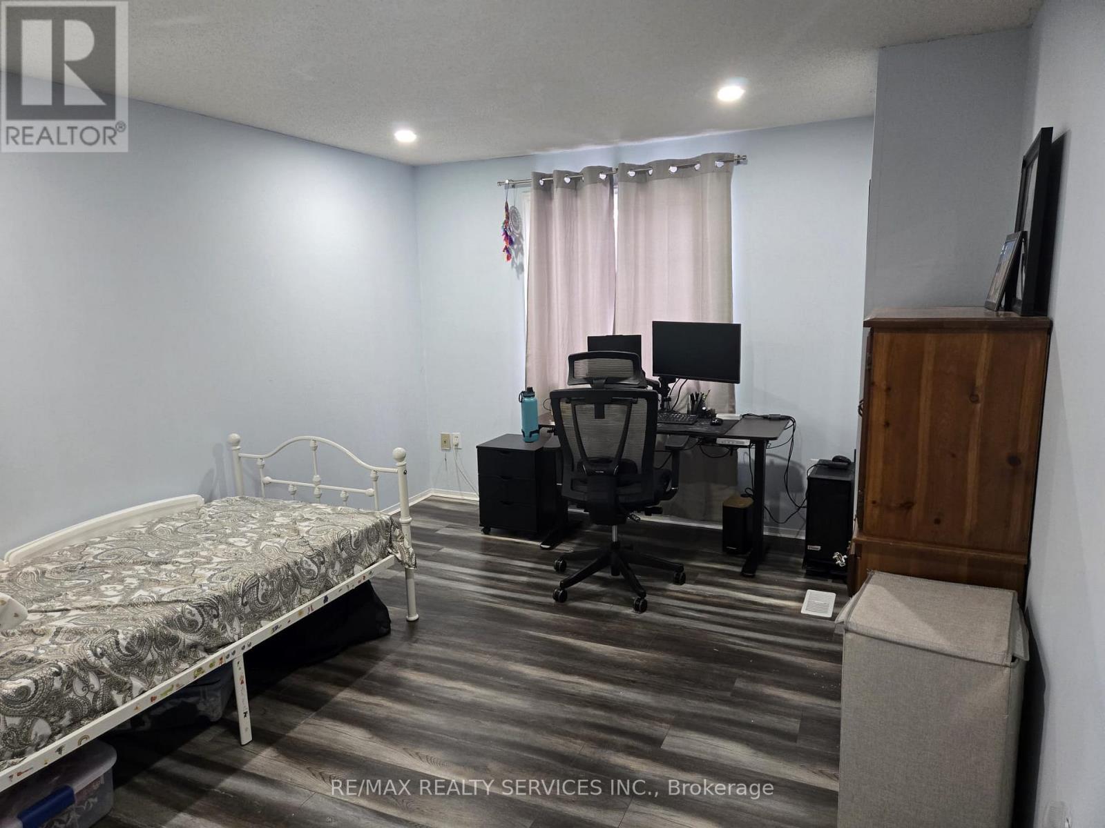 A bedroom with a bed, desk, and chair.