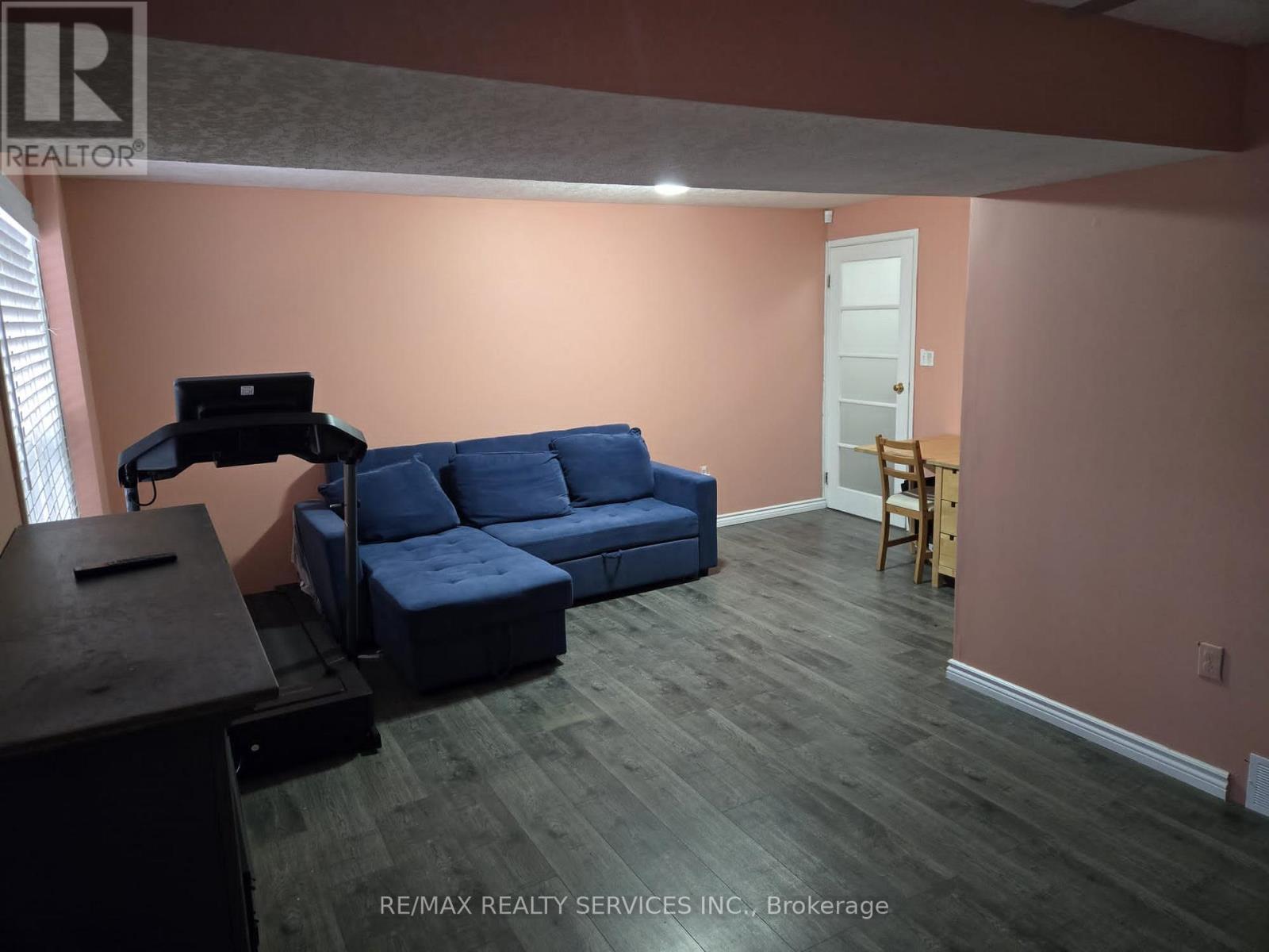 A living room with a blue couch and a wooden table.