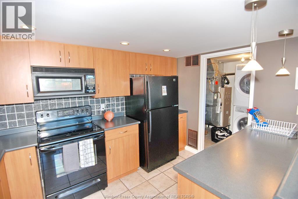 A kitchen with wooden cabinets and black appliances.