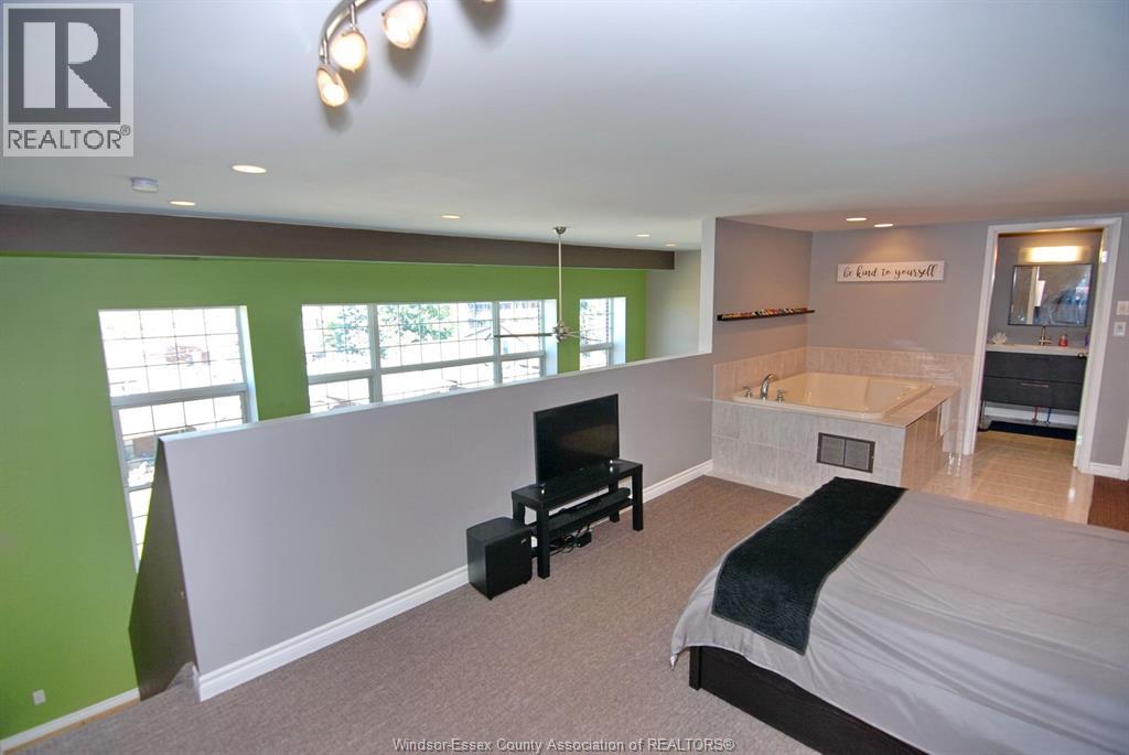 A bedroom with a bed, a chair, and a television.