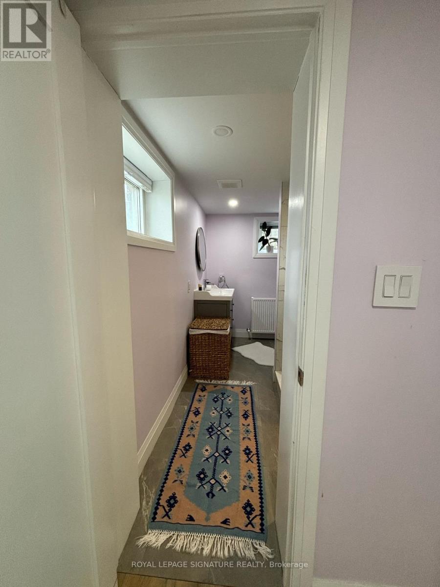 A bedroom with a bed, a white rug, and a television.