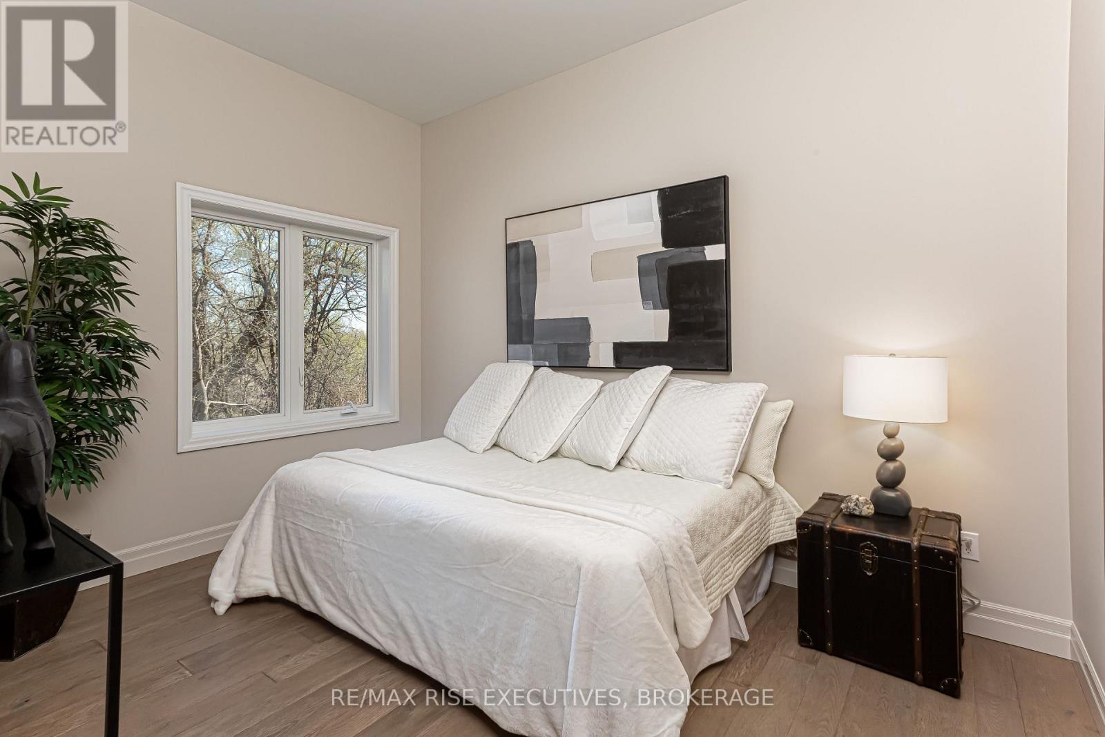 A bedroom with a white bed and a black lamp.