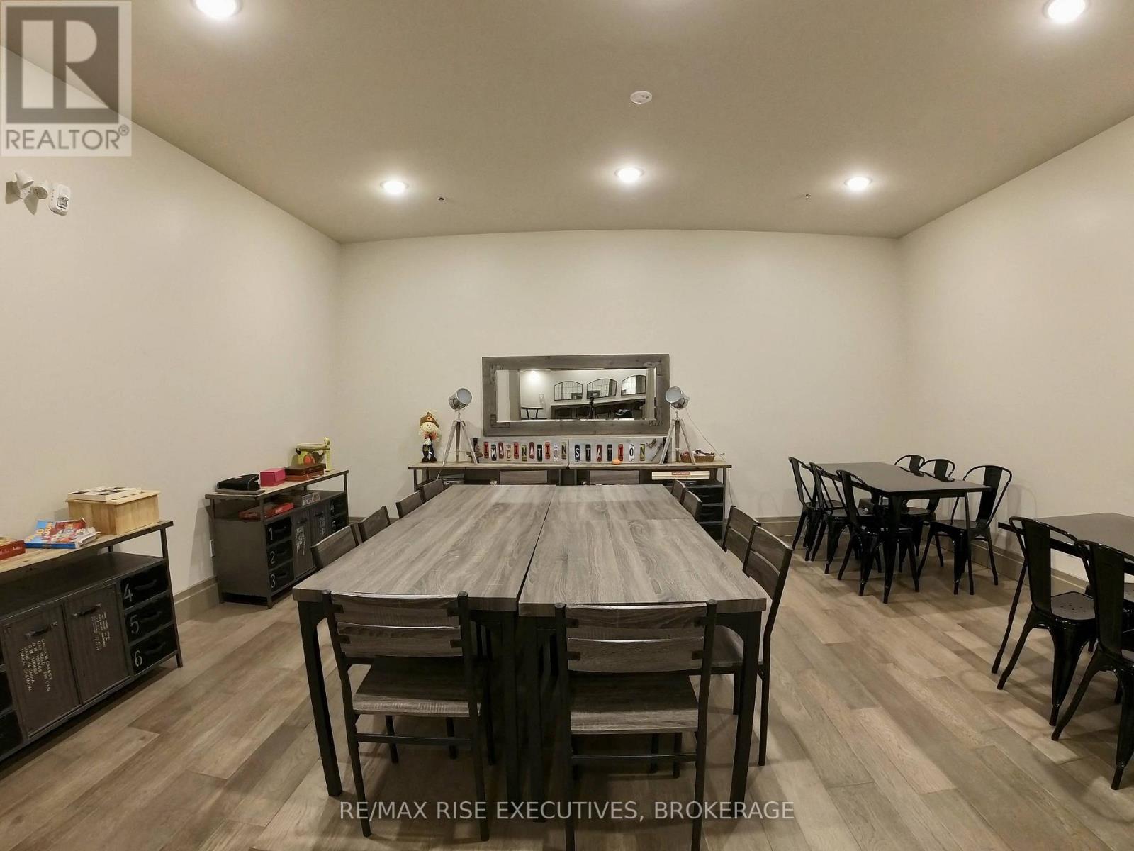 A dining room with a large table and chairs.