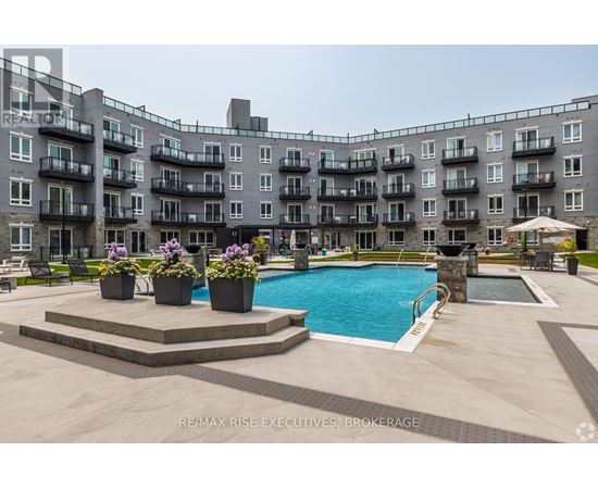 A large apartment complex with a pool and a patio area.