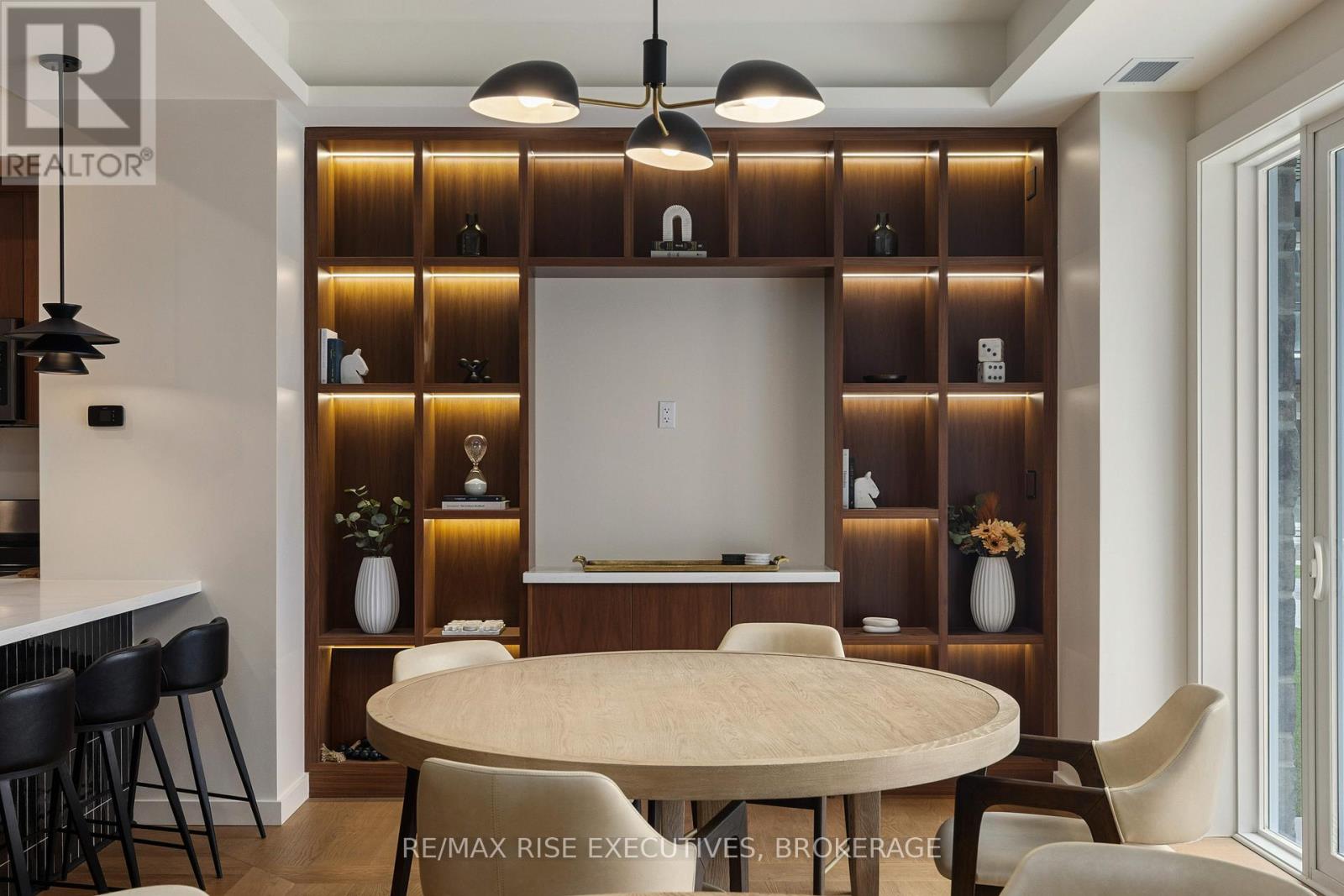 A modern dining room with a round table and chairs.