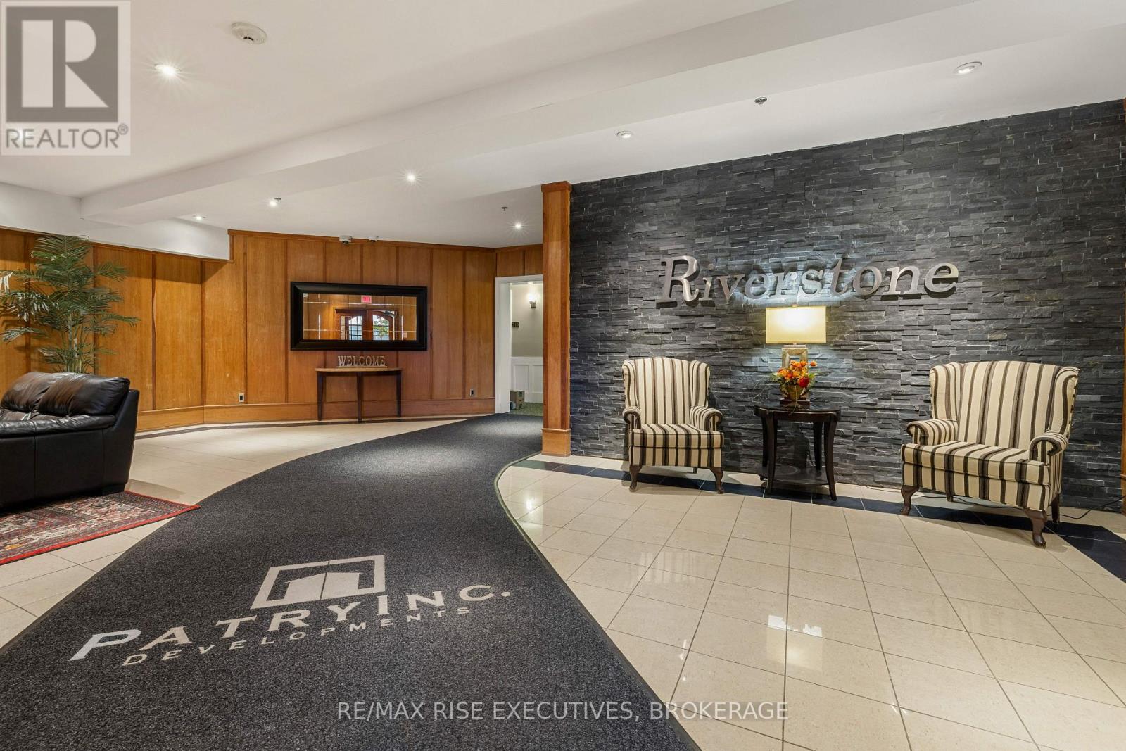 A living room with a black carpet that says "PATRYNCE" on it.