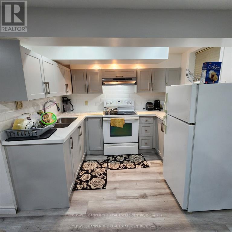 A kitchen with white appliances and a black and white rug on the floor.