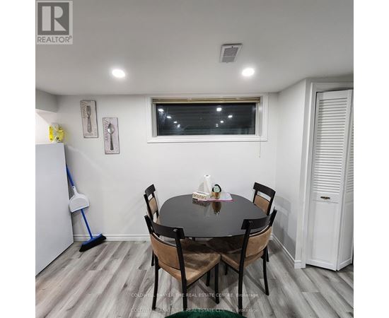 A dining room with a table and chairs.