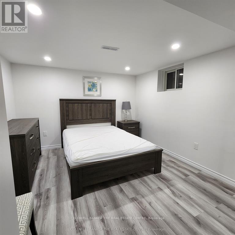 A bedroom with a bed, nightstand, and lamp.