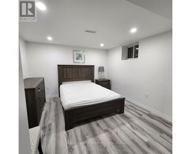 A bedroom with a bed, nightstand, and lamp.