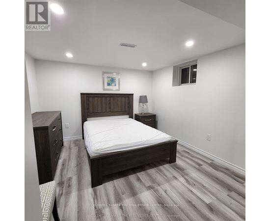 A bedroom with a bed, nightstand, and lamp.