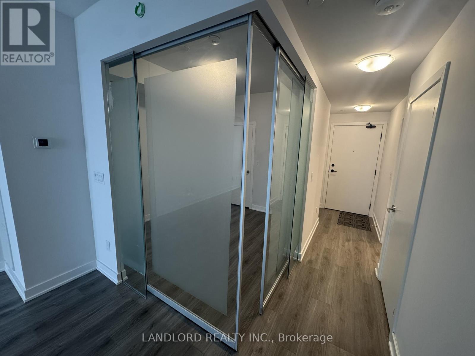 A glass door in a white room with a sign that says "REALTOR".