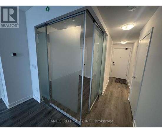 A glass door in a white room with a sign that says "REALTOR".