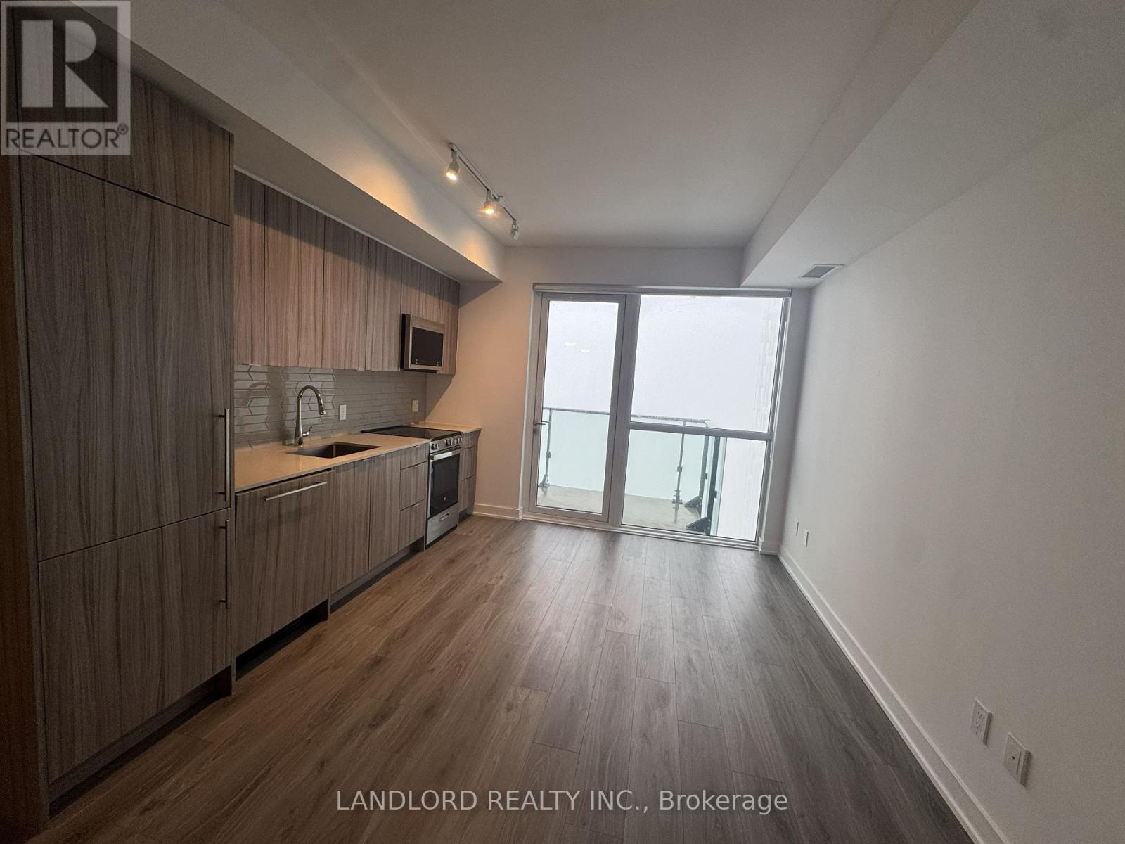 A spacious kitchen with wooden cabinets and a large window.